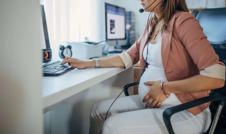 Mulher grávida trabalhando em computador para ilustrar decisão do TST que reconheceu estabilidade para gestante em contrato temporário